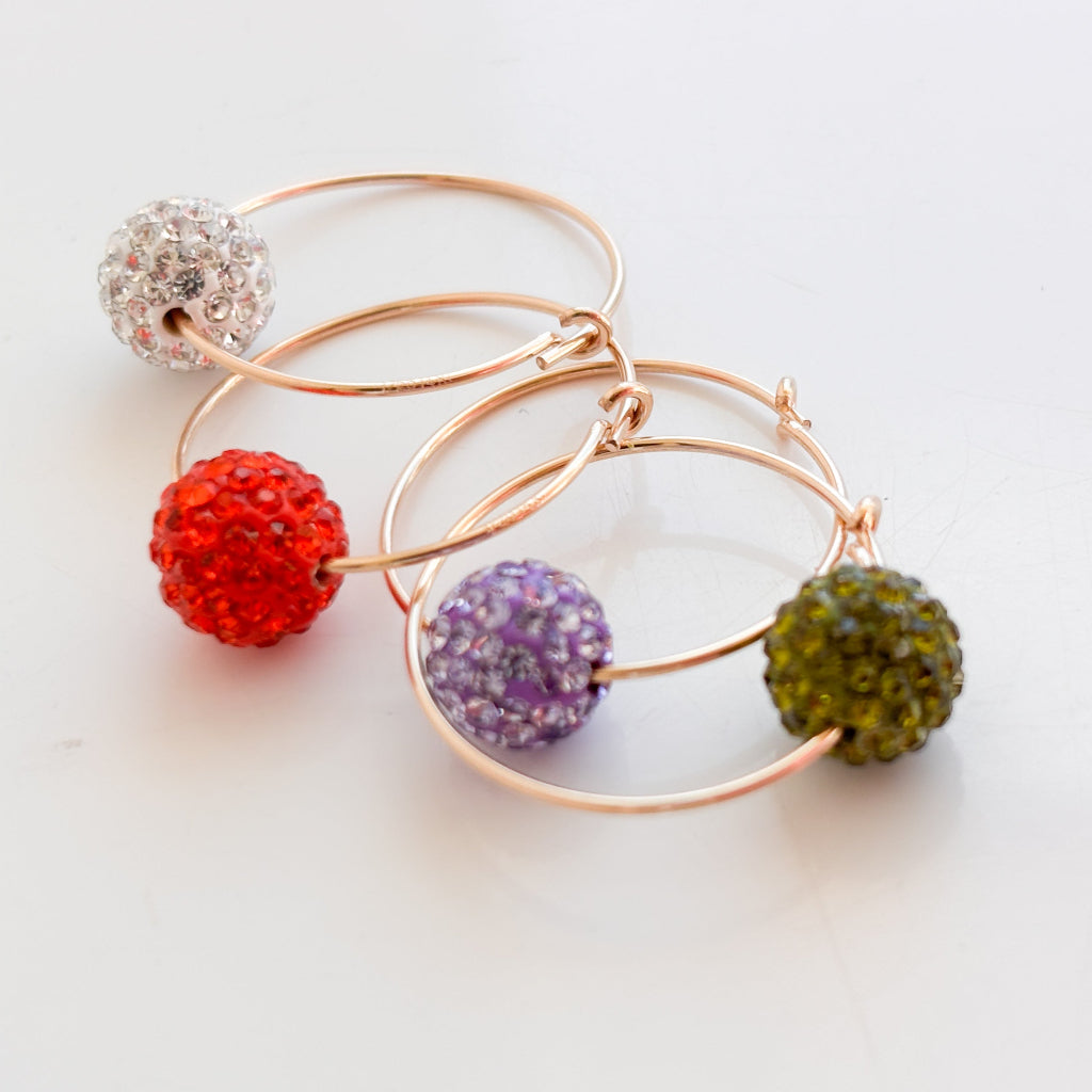 14k gold filled pave crystal ball hoop earrings shown in 4 colors; violet, olive green, orange-red, and clear.