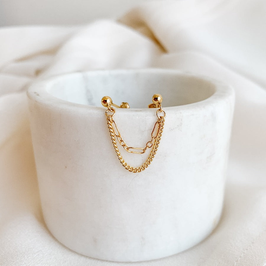 double piercing earring in 14k gold filled featuring two draped chain in long and short links and curb chain links that dangle from gold ball stud earrings.
