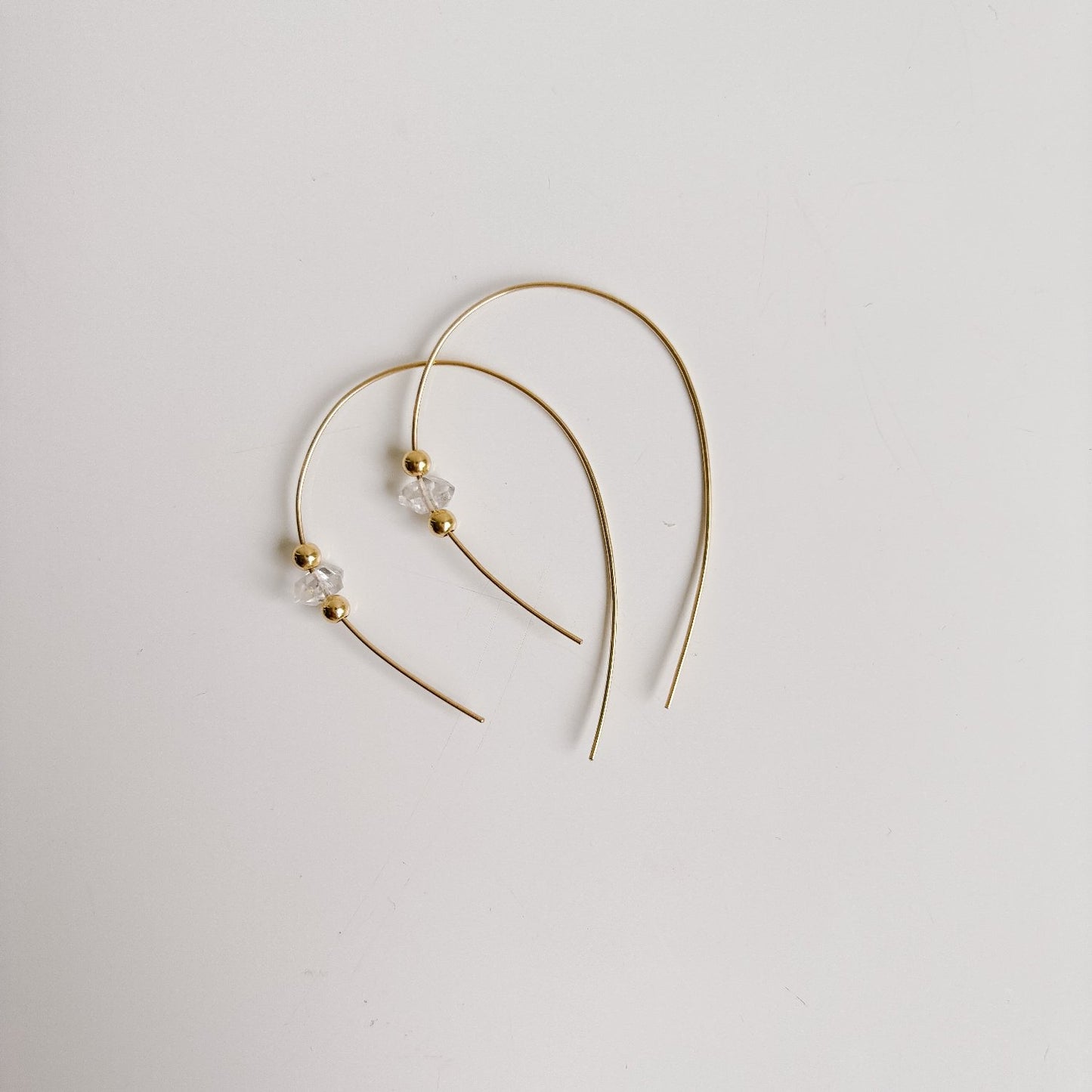 minimalist open hoop earrings in 14k gold filled featuring a single Herkimer Diamond with tiny gold sphere accents threaded onto the wire.