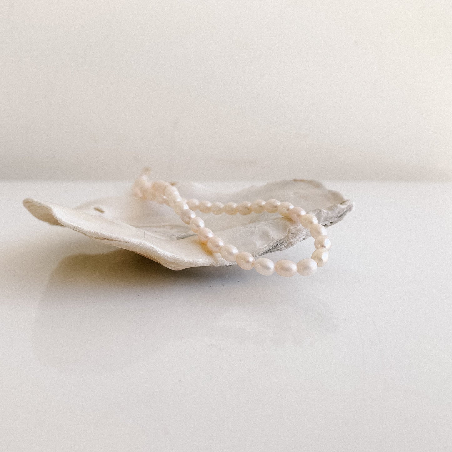 a pearl strand necklace showcasing tiny oval-shaped freshwater pearls.