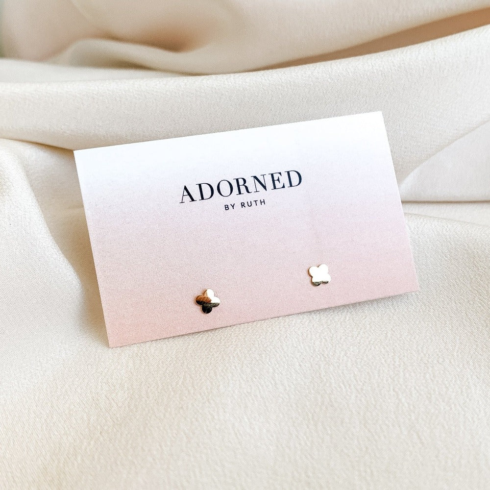 mini 4 leaf clover earrings in 10K yellow solid gold shown on a branded jewelry card - Adorned By Ruth