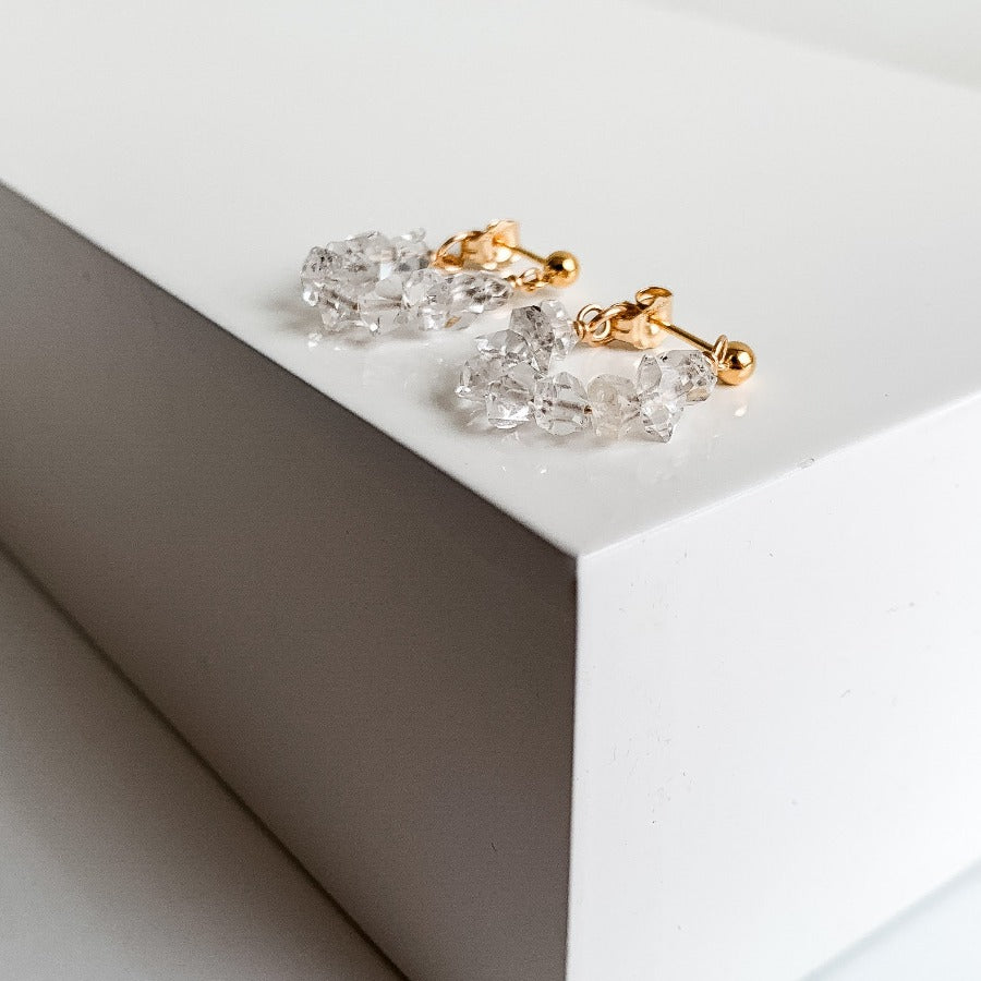 ADORNED By Ruth handcrafted in 14K gold filled, a string of Herkimer Diamonds connected to small ball stud earrings wrap around your ear lobe.