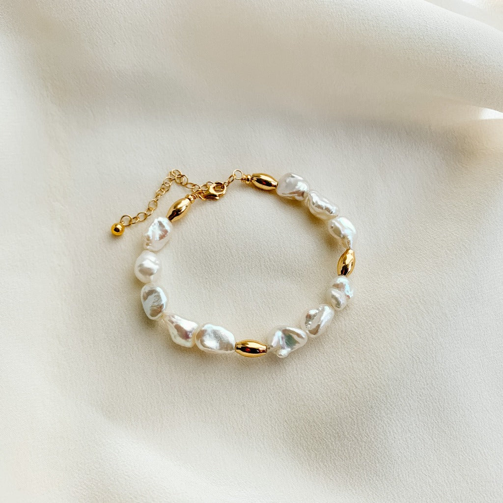 freshwater keshi pearl bracelet by Adorned by Ruth. Sections of textured pearls are accented with gold oval beads. 14k gold filled.