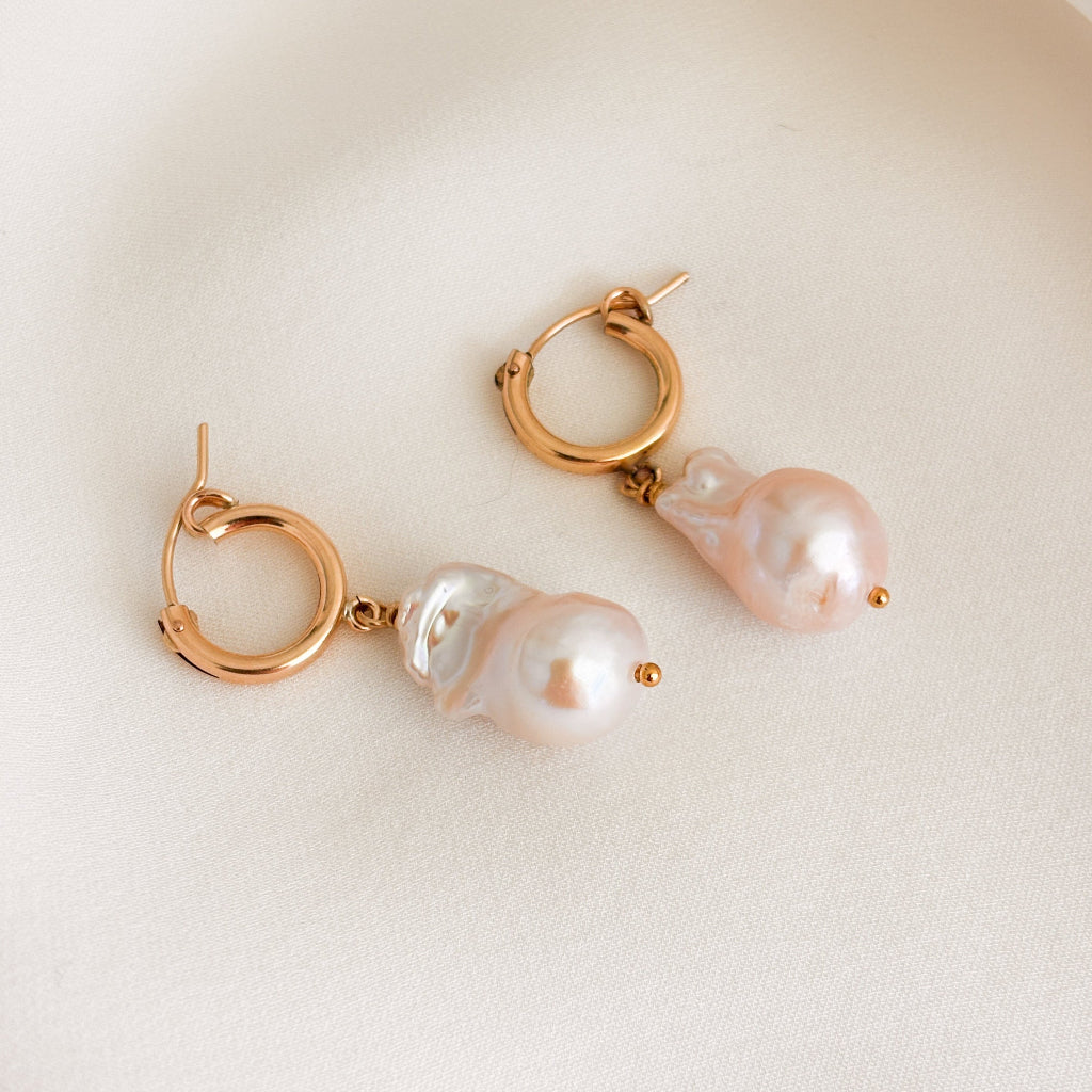 a pair of 14k gold filled hoop earrings featuring large baroque fireball pearl drops.