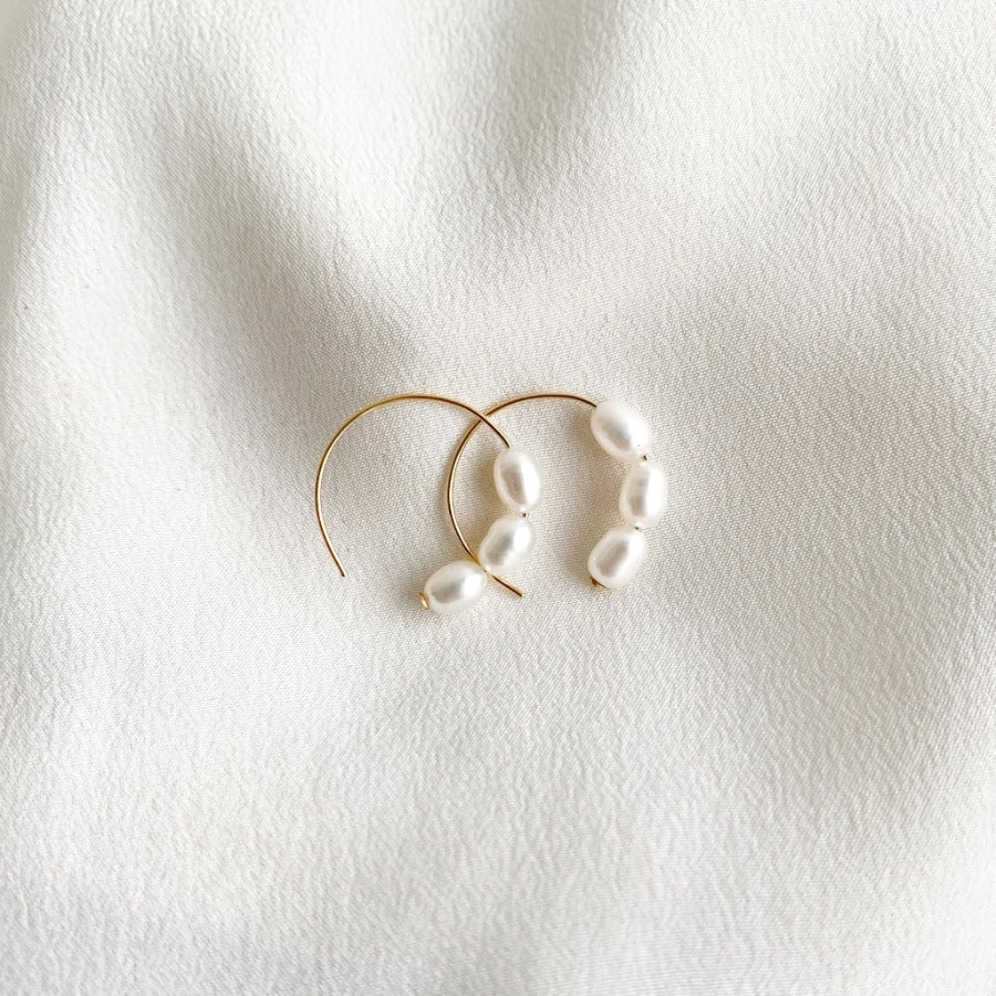 dainty circle hook earrings that feature three petite oval freshwater pearls. Crafted in 14k gold filled