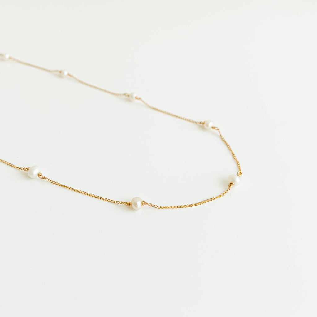 a dainty pearl station necklace in 14k yellow gold filled