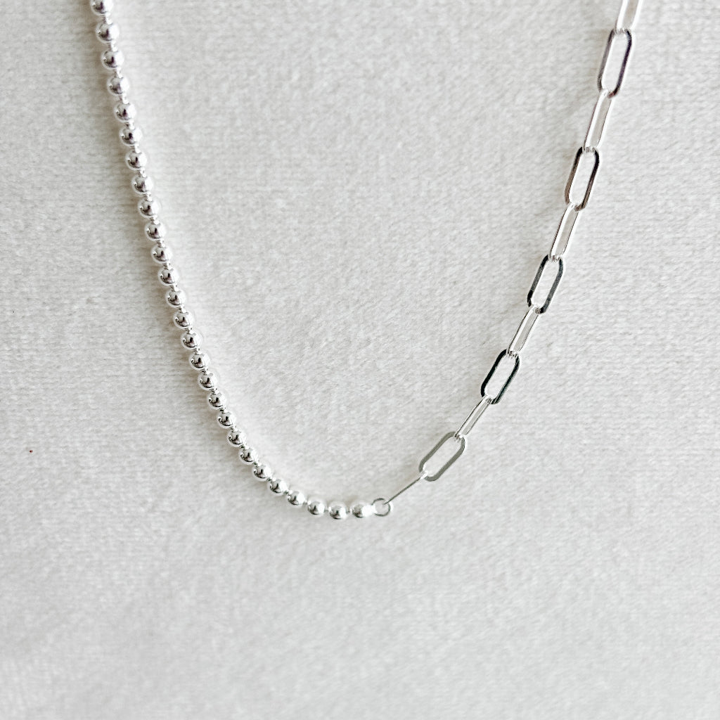 Silver chain anklet on a light gray background