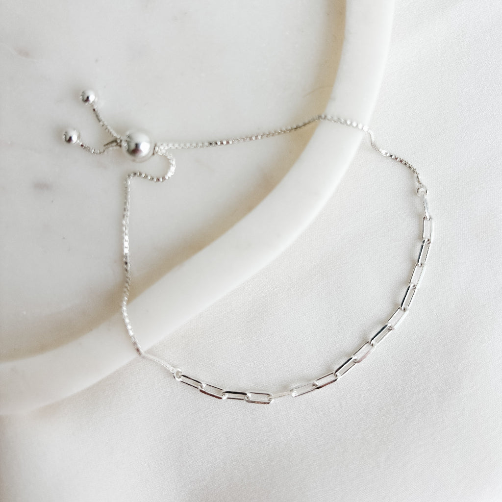 Silver anklet in paperclip and box chain mix on a marble surface