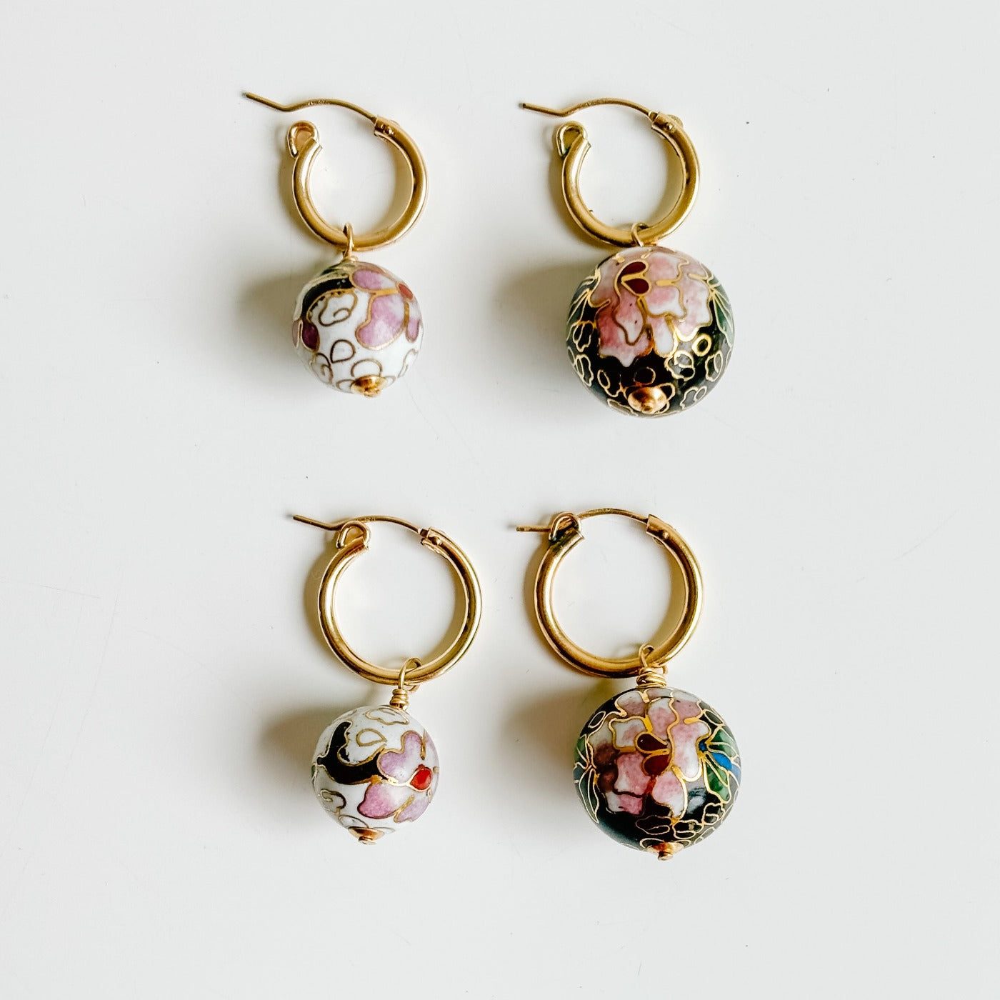 rare cloisonné charm hoop earrings shown in two sizes of hoops and two sizes of beads. 14k gold filled hoops come in small or medium and the cloisonné beads in white or black floral design are shown in medium 14mm and large 18mm.