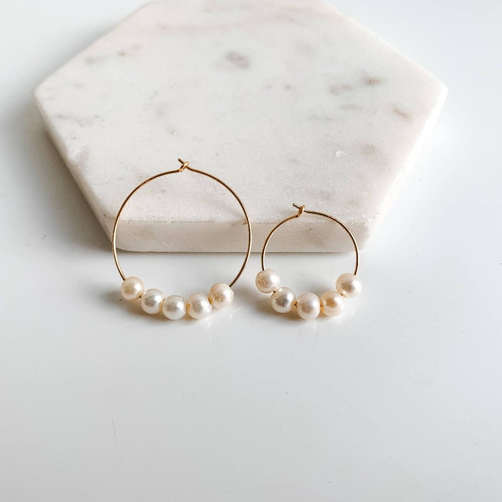 gold hoop earrings featuring a row of 5 freshwater pearls shown in two diameters, 20mm and 30mm. 