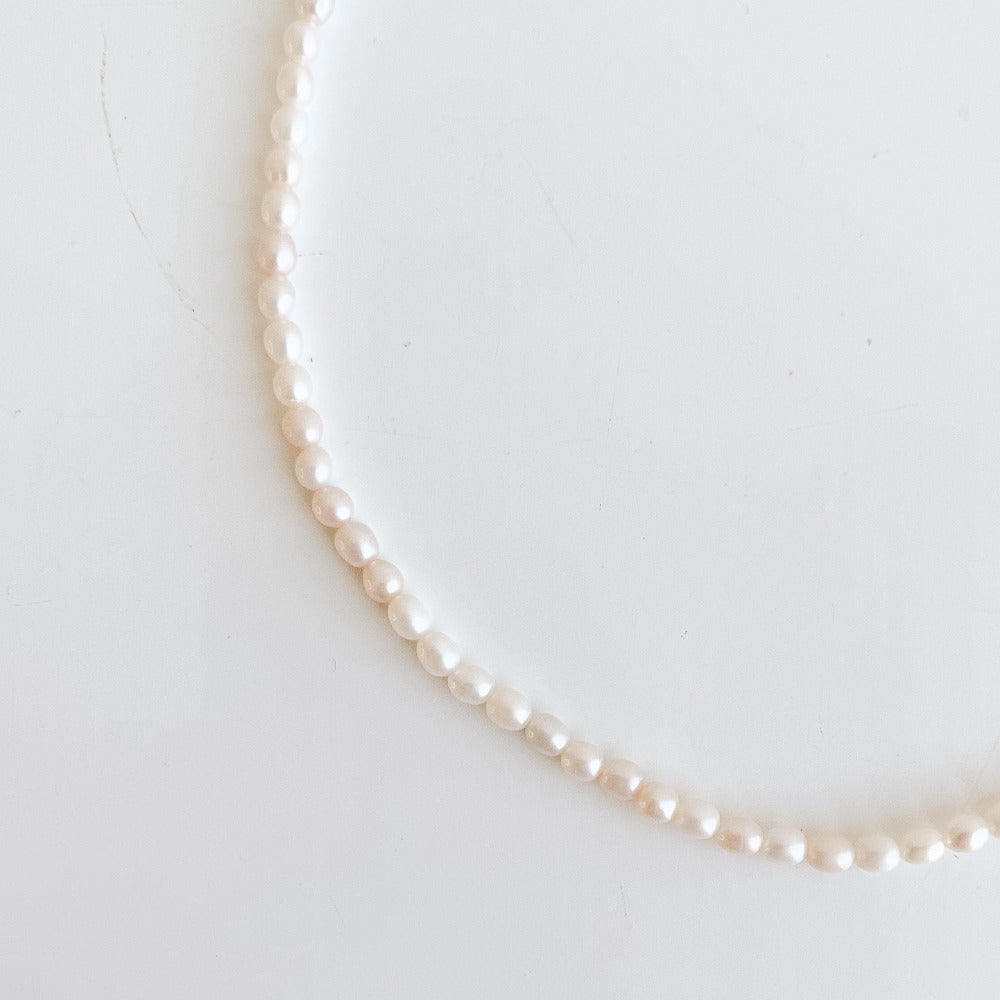 a classic pearl strand necklace featuring tiny oval-shaped freshwater pearls
