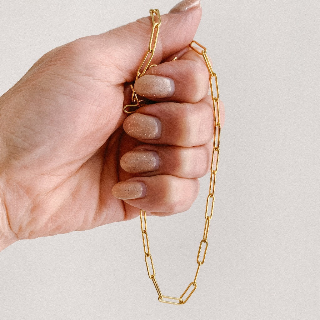 a large link paperclip chain necklace shown in hand .  The necklace is crafted in 14k gold filled and has 3.8mm x 11mm links.  