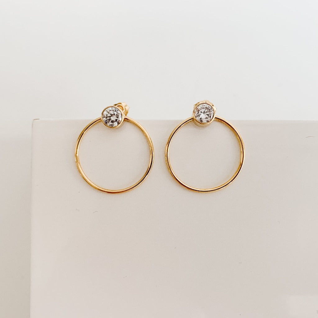 gold open circle cubic zirconia earrings.  Bezel set CZ post earrings with an open circle frame that can be worn in front of or behind the earlobe.  