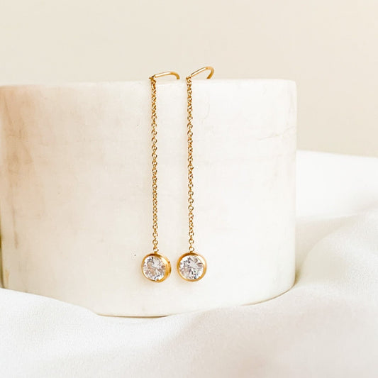A pair of gold filled threader earrings with solitaire CZ drops.  The threaders have a u-shaped cradle for extra security and are 3.5" long.  