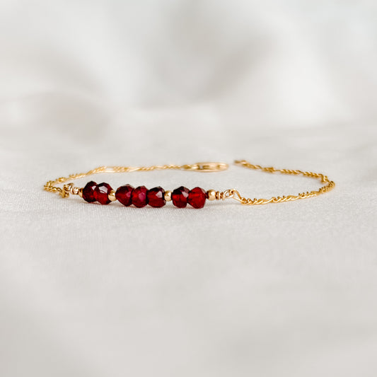 a dainty gemstone bar bracelet in 14k gold filled.  The five faceted round gemstones are accented with tiny gold ball beads and set into the Figaro chain.  