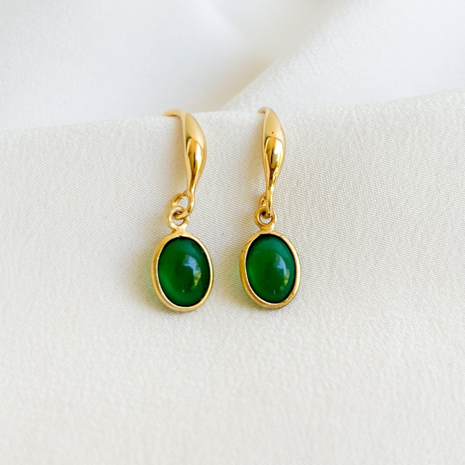 a pair of bezel gemstone earrings in 14K gold filled.  Bezel set oval green onyx gemstones dangle from thick gold hook ear wires.  