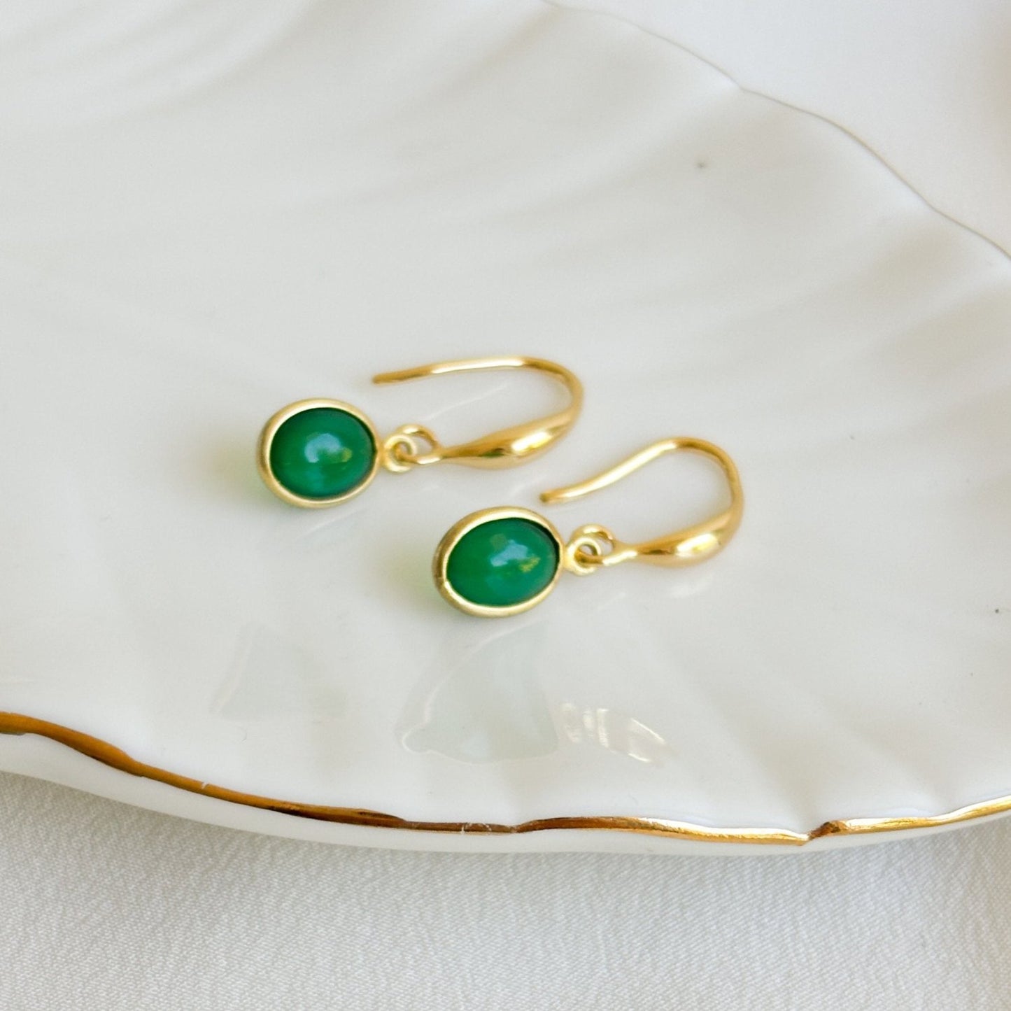 a pair of 14k gold filled hook ear wire earrings with oval bezel set green onyx gemstone charms.