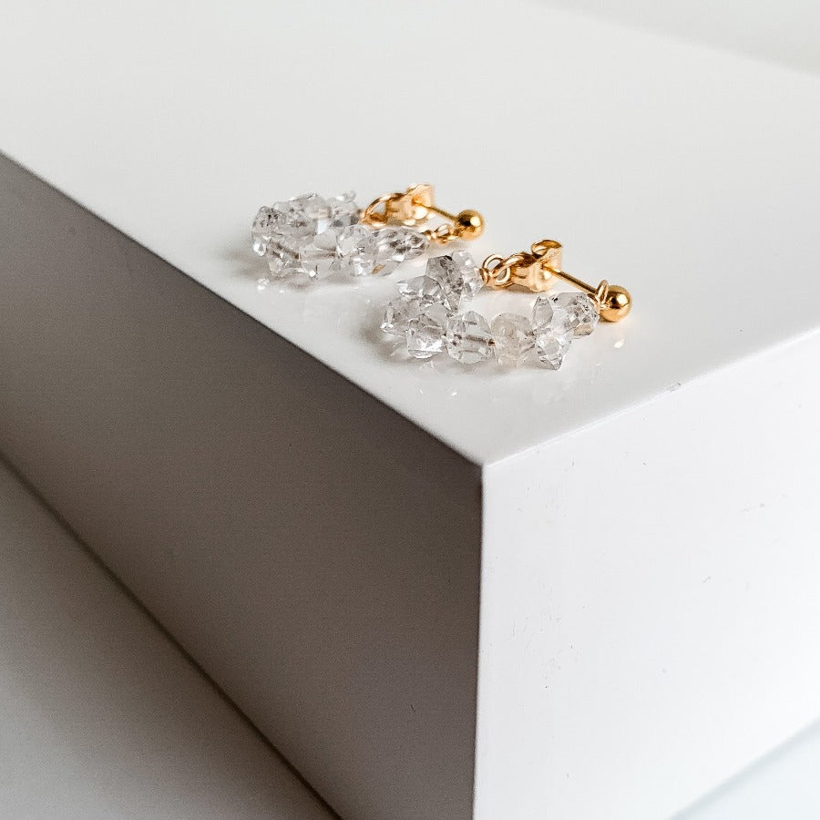 ADORNED By Ruth handcrafted in 14K gold filled, a string of Herkimer Diamonds connected to small ball stud earrings wrap around your ear lobe. 