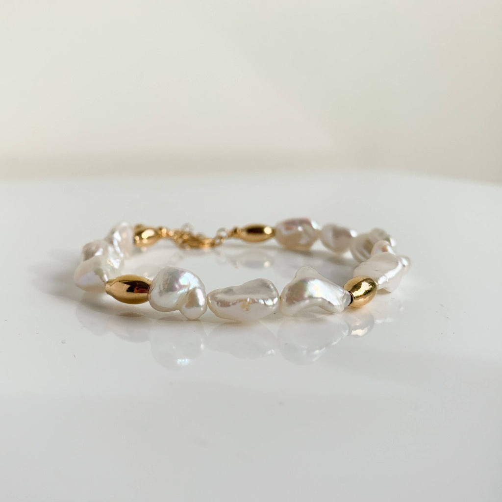 pearl beaded bracelet by Adorned by Ruth.  Keshi pearls are separated in sections by oval shaped gold beads.  