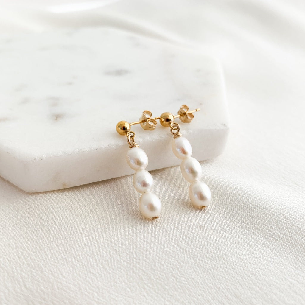 dainty gold sphere stud earrings that feature a drop of three petite oval  pearls