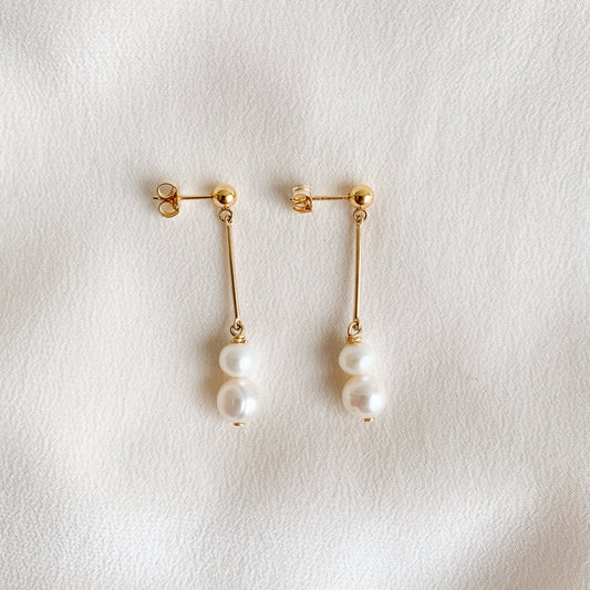 Dainty gold ball stud earrings that feature a gold bar and double pearl drops.  