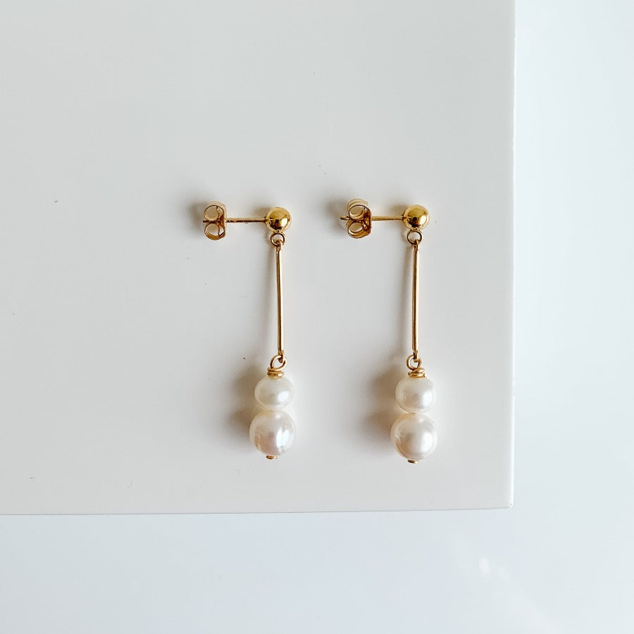 pearl drop earrings in 14k gold filled.  The gold ball studs feature gold bars and two pearls that dangle from the end. 