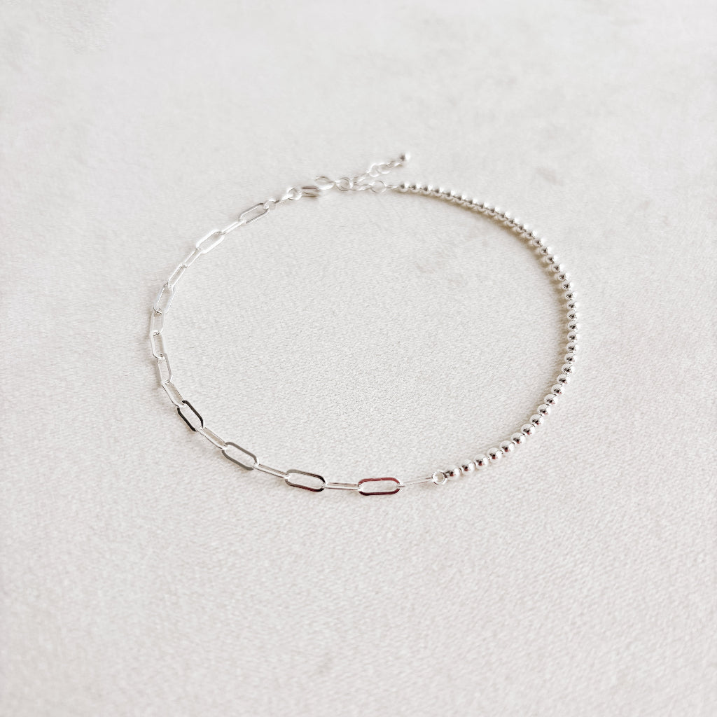 Silver anklet on a light gray background