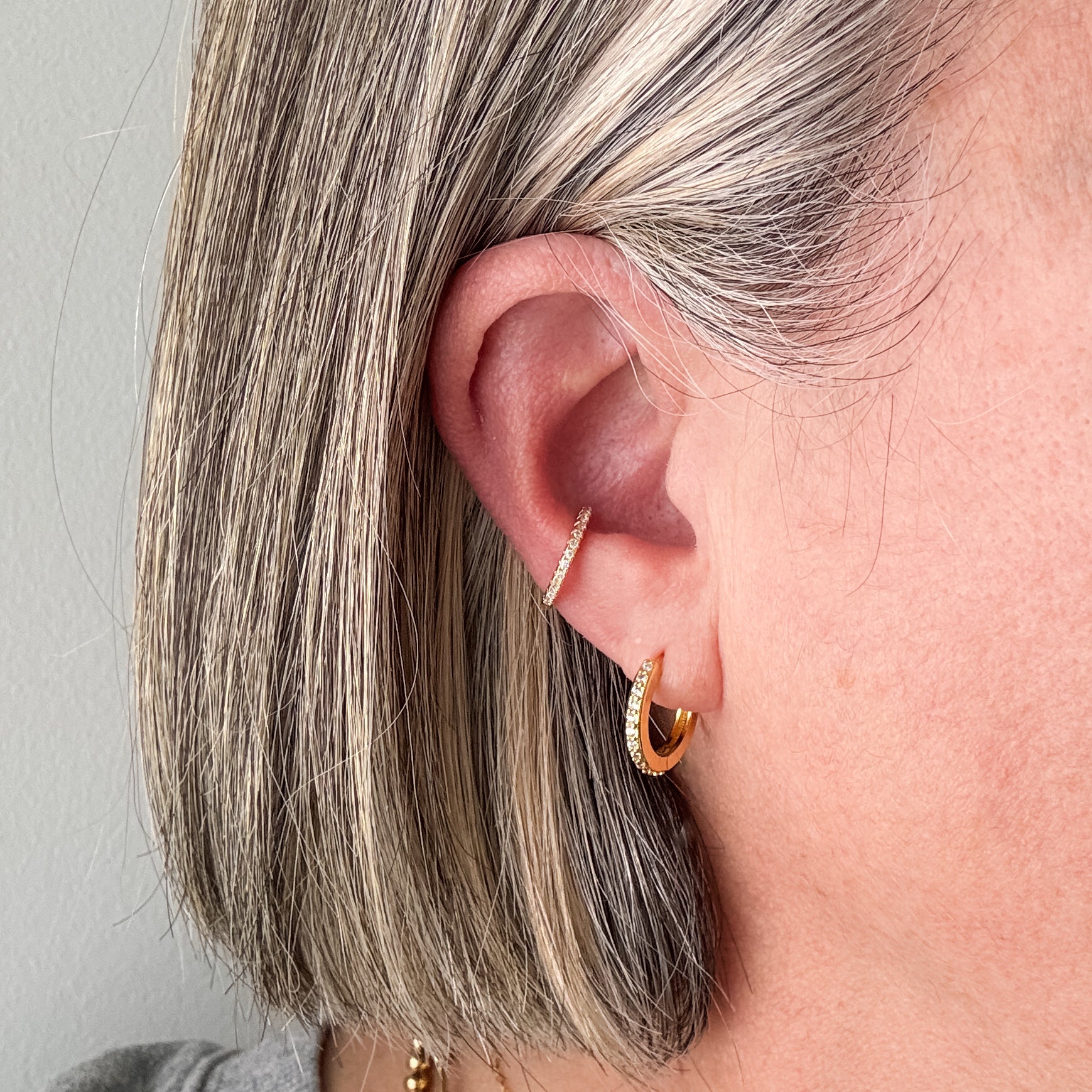 dainty 14k gold filled pave huggie hoop earring and matching ear cuff shown on ear lobe
