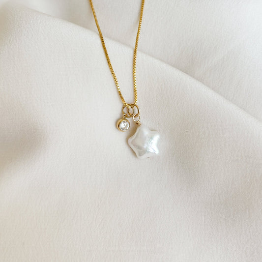 a dainty gold filled box chain necklace that features duo pendants, one a white star shaped pearl and the other a tiny round bezel cubic zirconia charm.  