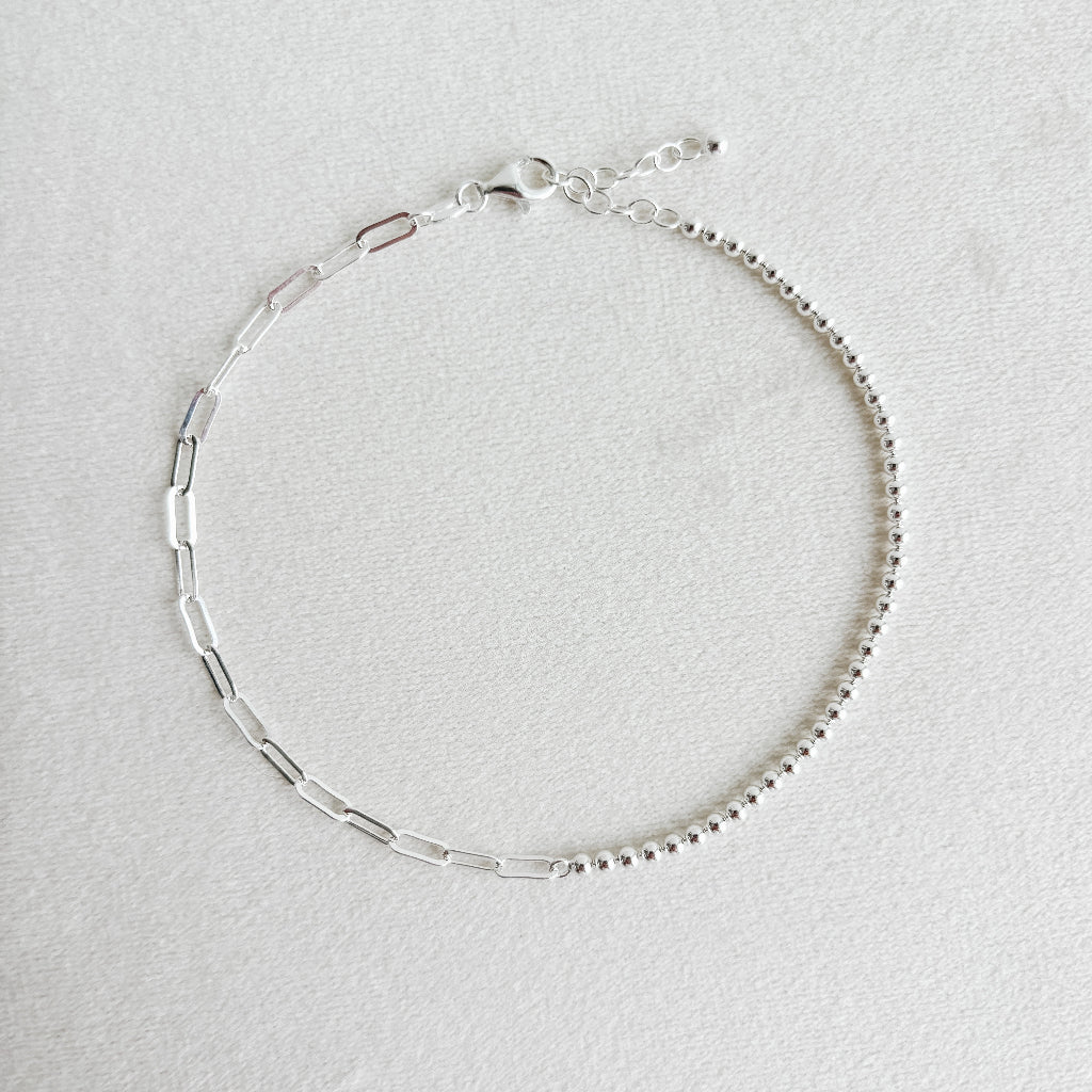 Silver mixed chain ankle bracelet on a light gray background