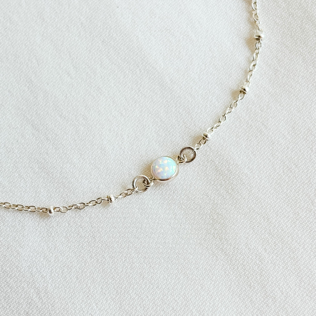 dainty beaded satellite chain sterling silver bracelet with bezel set opal.