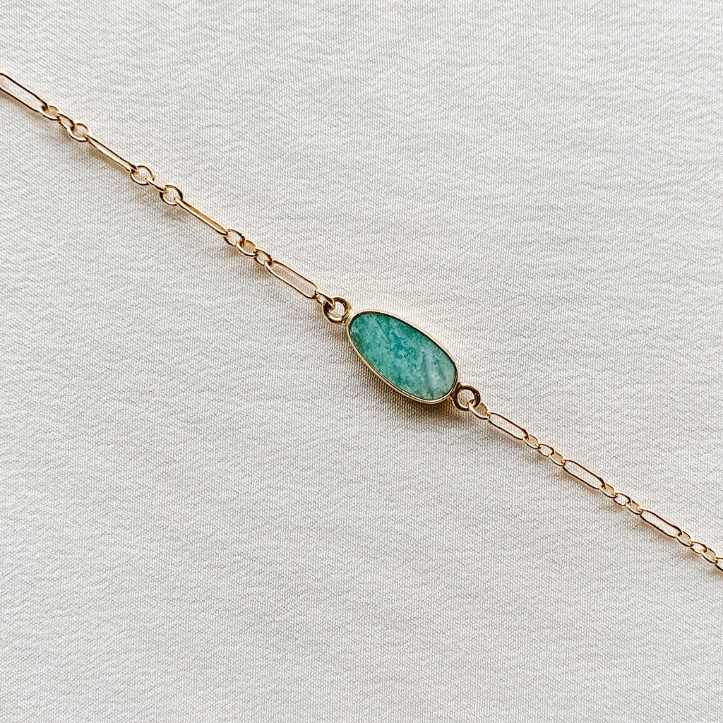 close up of flat slice of amazonite in gold frame on gold filled dainty long and short chain bracelet